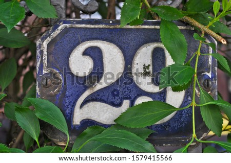 A house number plaque, showing the number twenty nine (29)