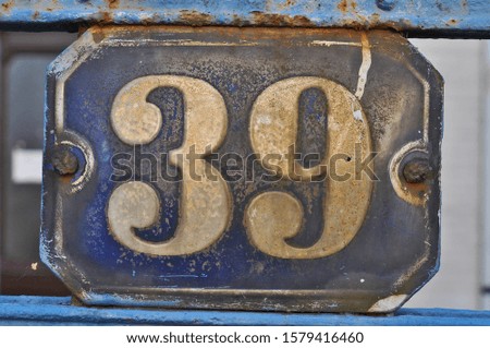 A house number plaque, showing the number thirty nine (39)