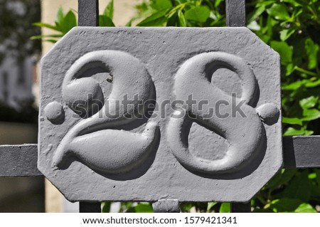 A house number plaque, showing the number twenty eight (28)