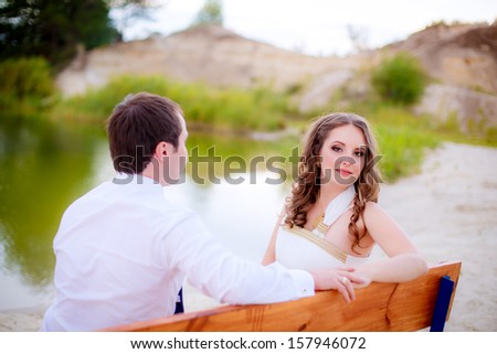 the couple on the bench. bride looks in the picture
