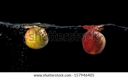 Apples in water on a black background.