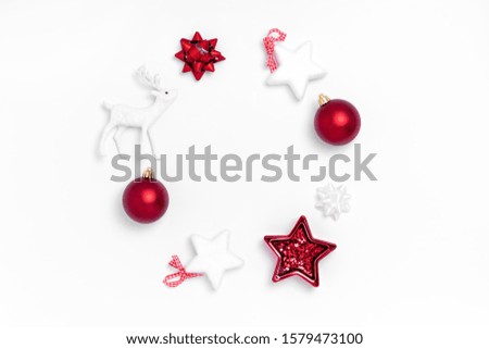 New Year and Christmas composition. Wreath from red balls, white stars, deer on white paper background. Top view, flat lay, copy space
