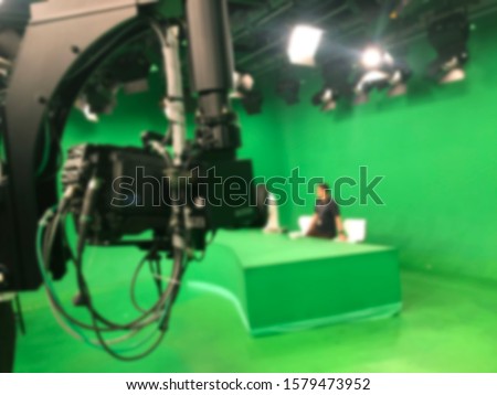abstract blurred of broadcast camera in studio with greenscreen at TV station.