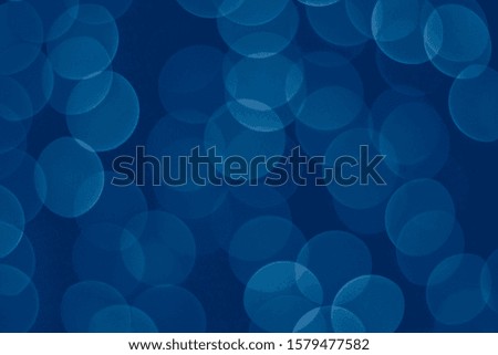 Color of the year 2020 Classic Blue. Blurred blue background with bokeh. Abstract texture. Circular points. Defocused bright festive light. 