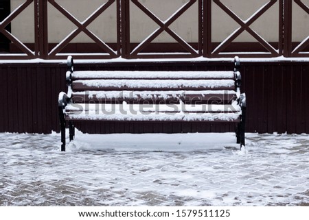 Park bench in retro style under the snow
