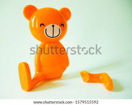 smiley bear ornament with broken leg, isolated on white background