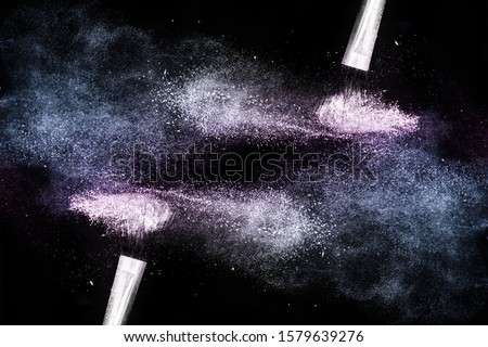 Cosmetic brush with purple and classic blue  cosmetic powder spreading for makeup artist or graphic design in black background, look like a lively and joyful mood.