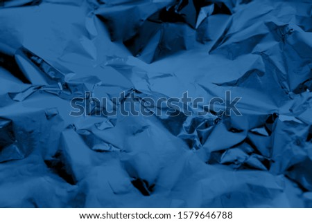 Abstract  dark blue colored crumpled foil texture background. 