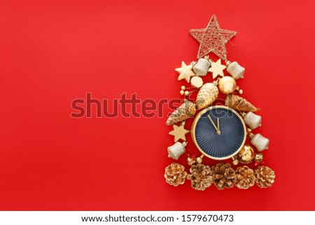 Christmas tree made of alarm clock and decor on color background
