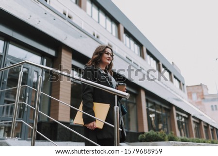 Beautiful girl walking in the city and drink a cofe in the autumn outdoor