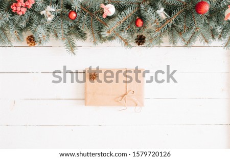 Christmas gift boxes and fir tree branch on wooden table. Top view with copy space. Christmas background, with fir branches, fairy lights, gift box and christmas decorations on white wooden plank