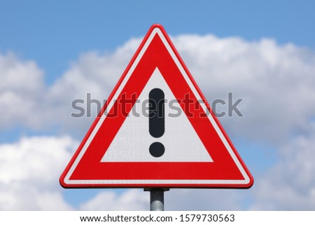 A sign with a exclamation mark warning for a dangerous situation ahead