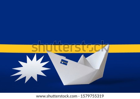 Nauru flag depicted on paper origami ship closeup. Handmade arts concept