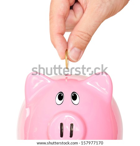 Piggy bank and hand with coin