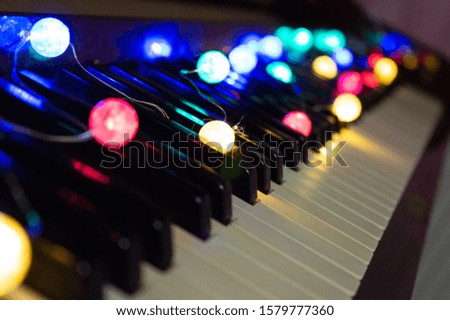 Colorful christmas lights on piano keyboards.