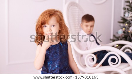 Brother and sister at winter Christmas studio. Two member of family. Happy child. Young couple posing