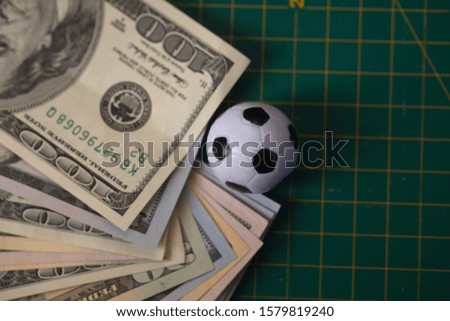 soccer ball on dollars bills. gambling sports betting concept