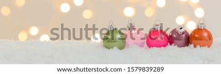 many different christmas items on white snow with many small, shining lights in the background