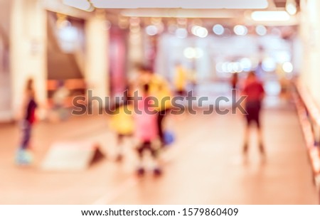 Vintage tone abstract blur image of Kids playing skate or rollerblades in skating rink with bokeh for background usage .