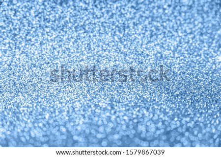 Delicate glitter bokeh background toned blue color. Creative and moody color of the picture