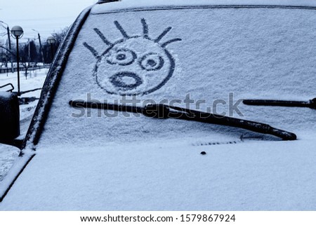 drawing on the windshield of the car, winter weather.