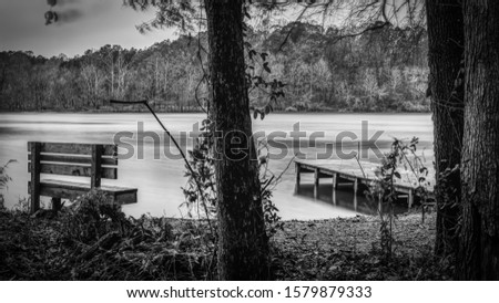 A bench and pier on a calm lake in Saxapahaw, North Carolina