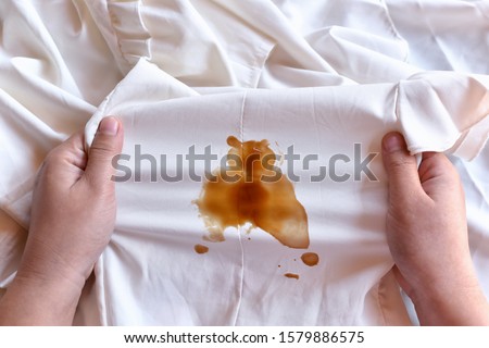 Dirty sauce stain on fabric from accident in daily life. Concept of cleaning stains on clothes or cleaning the house. Selected focus Royalty-Free Stock Photo #1579886575