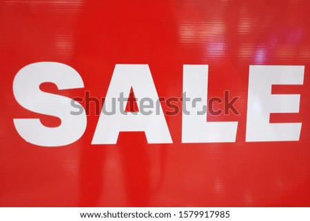 A SALE wording on a red board in front of a fashion store