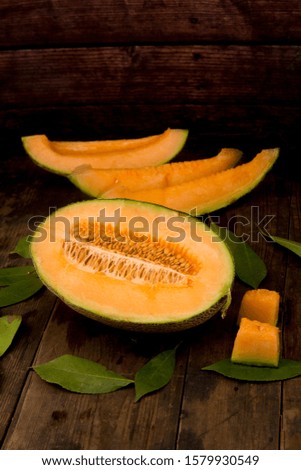 Cut honeydew melon and green leaves