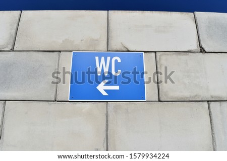 Sign with inscription WC toilets on concrete wall