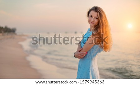 Young woman walking on a tropical beach. Sunset on the background. Phu Quoc island, Vietnam.