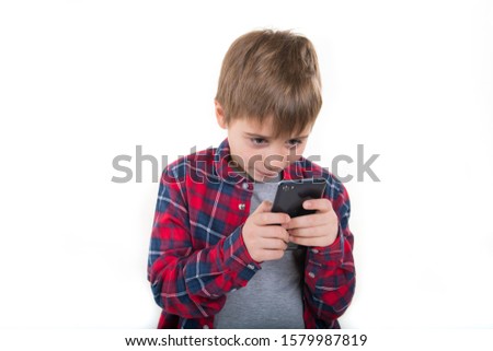 
boy has fun playing the phone. in a stylish shirt. isolated on white background Royalty-Free Stock Photo #1579987819