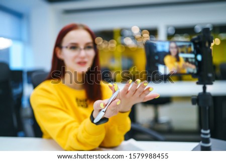 Hands of young blogger is recording video and talking with gesturing about startup small business.Teenager student in a yellow sweater having fun vlogging live feeds on social media. Recording webinar