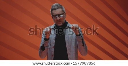 Medium shot of a furious middle-aged man clenching his fists and glaring at the camera