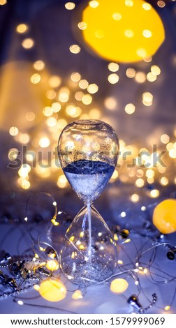 Christmas background, hourglass with silver sand. Vacation approaching concept. Happy New Year