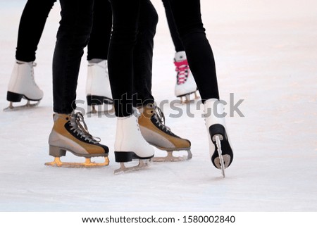 Ice skating, female feet at the ice rink. Girls in the skates, winter sports and fun