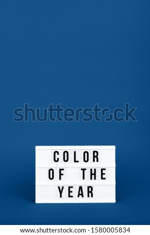 Retro lightbox with Color of the year wording on the trendy solid blue backdrop in vertical format, place for text