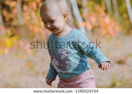 Adorable girl having fun on beautiful autumn day. Authentic picture.