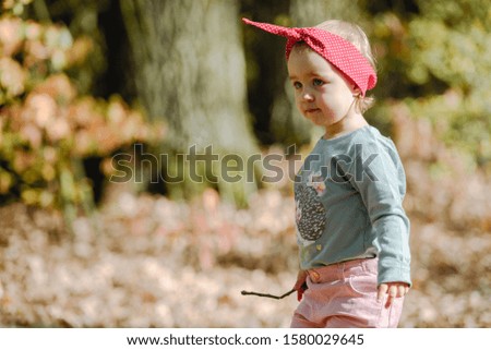 Adorable girl having fun on beautiful autumn day. Authentic picture.