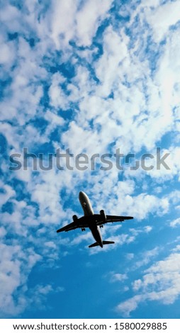 Commercial airplane flying in a blue cloudy sky. Portrait capture. Travel abroad and business concept.