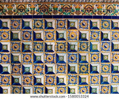Ceramic mosaic pattern.Colorful floral background. Ceramic mosaic close up. Andalusian ceramic wall. Dirty floral wall fragment photo. Contrast. Tile