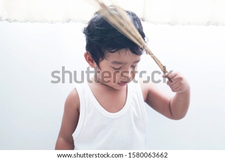 2 year old Asian boy Buddhist Holding a holy water in Thailand, standing with his eyes closed, praying for the blessing of the religion, white background image                                        