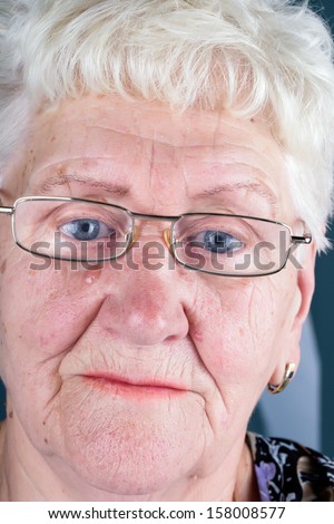old woman with blue eyes in glasses close up picture