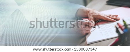 Businessman signing a document in office (lorem ipsum text used; panoramic banner