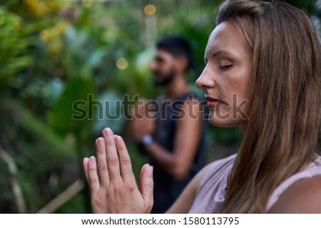 Young, healthy millennial couple practicing yoga together with a