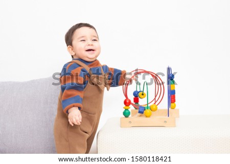 Cute baby smlie and play wood toy  at  white background