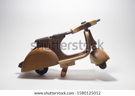 Close-up of miniature hand made toy motorcycle on rustic white background