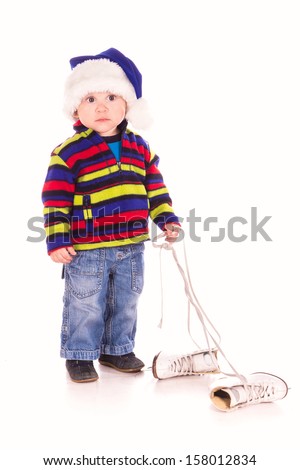 Cute little boy in Santa's hat with figure skates isolated