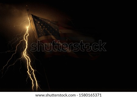 lightning strikes behind the American flag