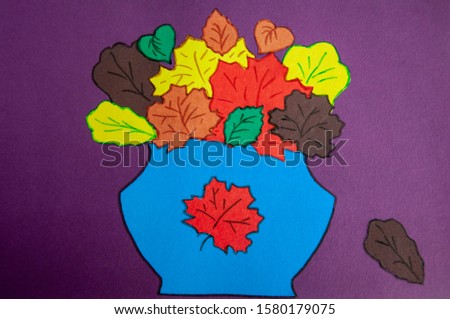 Hand-made picture of lovely leaves. Painted with yellow, green, orange, brown colors on the dark background. Autumn applique